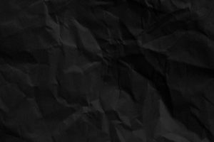 Abstract crumpled black paper texture background for design